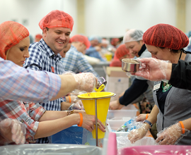 Volunteers at meal packing event to give food to hungry families in need